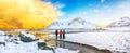 Group of tourist looking fabulous winter scenery on Skagsanden beach with illuminated clouds during sunrise