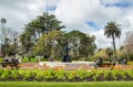Group of tourist visitors relaxing and resting on the chair around a large cast iron fountain in Albert Park. Royalty Free Stock Photo