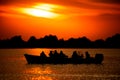 Group of tourists on the boat watching sunset in Danube Delta Romanian wild life