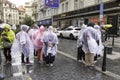 Group of tourists dressed in Raincoats waiting to cross the Street