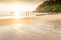 Group of tourists enjoying sunset beach.