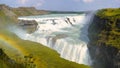 Group of tourists enjoying the view of Gullfoss falls and its greenery on a sunny day in Iceland