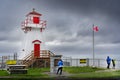 A group of tourists exploring a historic lighthouse and popular local attraction along the Canadian East Coast.