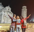 tourists friends travel in Pisa, Italy, looking at the leaning tower and piazza dei miracoli at night time Royalty Free Stock Photo