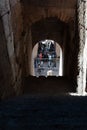 Group of tourists gathered in shade under arch at end of corridor inside Coliseum.tourists outside Coliseum Royalty Free Stock Photo