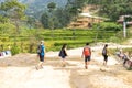 A group of tourists hiking in Asian villages among paddy fields in Nepal