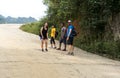 A group of tourists hiking in Asian villages among paddy fields in Nepal