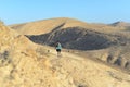 Group of tourists hiking. Group of travelers on a trail in an Israeli desert mountains, Ramon crater valley. backpackers tourists Royalty Free Stock Photo