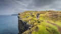 Group of tourists hiking and sightseeing iconic Cliffs of Moher, Ireland