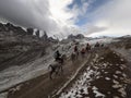 Group of tourists horseback riding in snowy winter landscape on path to Vinicunca Rainbow Mountain near Cusco Peru Andes Royalty Free Stock Photo