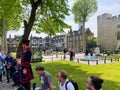 A group of tourists listening to a guided tour of the Tower of London on a beautiful sunny day in London, England. Royalty Free Stock Photo