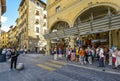 A group of tourists pass souvenir, leather and gift shops in Florence Italy