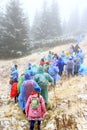 Group of tourists in raincoats on hike in mountains. Travel concept Royalty Free Stock Photo