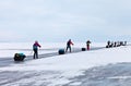 Tourists travel on ice skates on the frozen Baikal Lake