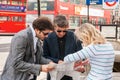 Group of tourists standing at Trafalgar Square and looking at map