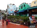 A group of tourists stroll down a street in the colorful Gamcheon culture village in Busan