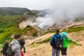 Group of tourists and travelers watching beautiful volcanic landscape, eruption fumarole, hot springs, gas-steam