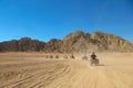 Group of tourists travels through the desert on a Quad bikes