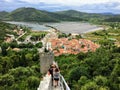 A group of tourists walking down along the the Walls of Ston, towards the ancient town of Ston, Croatia below.