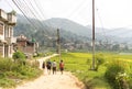 Group of tourists walking on the road in Nepali asian village