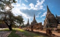 Group of tourists walking to admire the beauty of ancient pagodas in the historical park