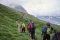 Group of tourists walking uphill in mountains. Royalty Free Stock Photo