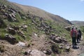 A group of tourists walks along a mountain trail in Altai in summer.