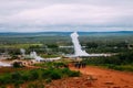 A group of tourists watching the eruption of a little bath and a couple in the geyser valley in Iceland Royalty Free Stock Photo