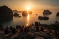 A group of tourists watching the sun set over Halong Bays magnificent seascape of limestone islands and karst mountains. Showcase
