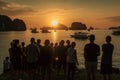 A group of tourists watching the sun set over Halong Bays magnificent seascape of limestone islands and karst mountains. Showcase