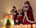 A group of toy Christmas singers with a small Christmas tree, bright balls and a bright star