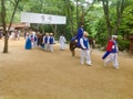 A group of traditionally dressed Koreans walk through the village for the tourist show