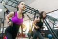 Group training with loops in the gym, two young attractive fitness women doing cross fit with straps system. Sport, teamwork, Royalty Free Stock Photo