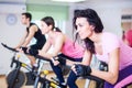 Group training people biking in the gym, exercising legs doing cardio workout cycling bikes Royalty Free Stock Photo