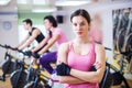 Group training people biking in the gym, exercising legs doing cardio workout cycling bikes Royalty Free Stock Photo