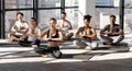 Group Training. Sporty multiethnic people meditating together in modern studio, practicing yoga Royalty Free Stock Photo