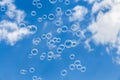 A group of transparent rainbow soap bubbles on the blue sky with white clouds background Royalty Free Stock Photo