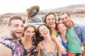 Group of travel friends taking selfie in the desert during a roadtrip - Happy young people having fun traveling together