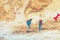 Group of traveler  miniature figures with backpack standing on old map. Royalty Free Stock Photo