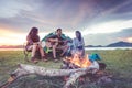 Group of travelers camping and doing picnic and playing music together. Mountain and lake background. People and lifestyle. Royalty Free Stock Photo