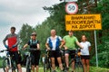 Group of travelers cyclists, road sign pointer, Belarus, Grodno, August 2017