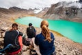 Group of trekker backpackers sitting relaxing at bank of Beautiful landscape of turquoise Ala-Kul Lake, Karakol valley, Issyk-kul Royalty Free Stock Photo