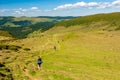 Group of trekkers hikers with backpacks descending with veiw of Maramures ridge from Rodna Mountains, Muntii Rodnei National Park Royalty Free Stock Photo