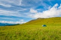 Group of trekkers hikers camping on grass meadow with view of Maramures ridge from Rodna Mountains, Muntii Rodnei National Park,