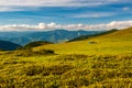 Group of trekkers hikers camping on grass meadow with view of Maramures ridge from Rodna Mountains, Muntii Rodnei National Park,