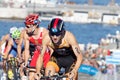 Group of triathlon competitors cycling uphill