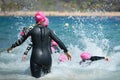 Group triathlon participants running into the water for swim portion of race