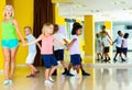 Group of tweens exercising folk dance, forming circle with femal