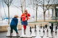 Group of two kids playing giant chess on playground