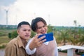 Group of two LGBTQ friends sitting and chatting and taking pictures. Along with laughing happily on the roof of the coffee shop Royalty Free Stock Photo